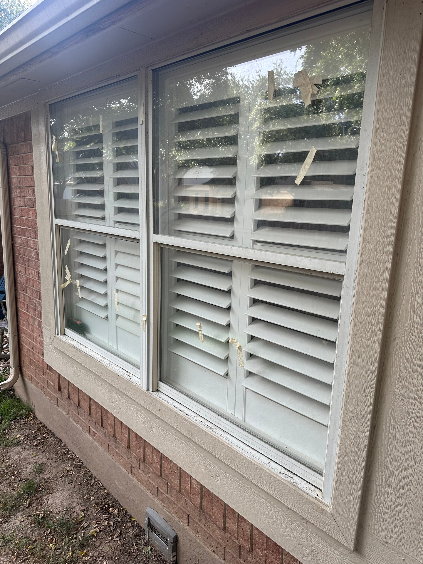 Austin home window with dust, tape residue and grime before cleaning