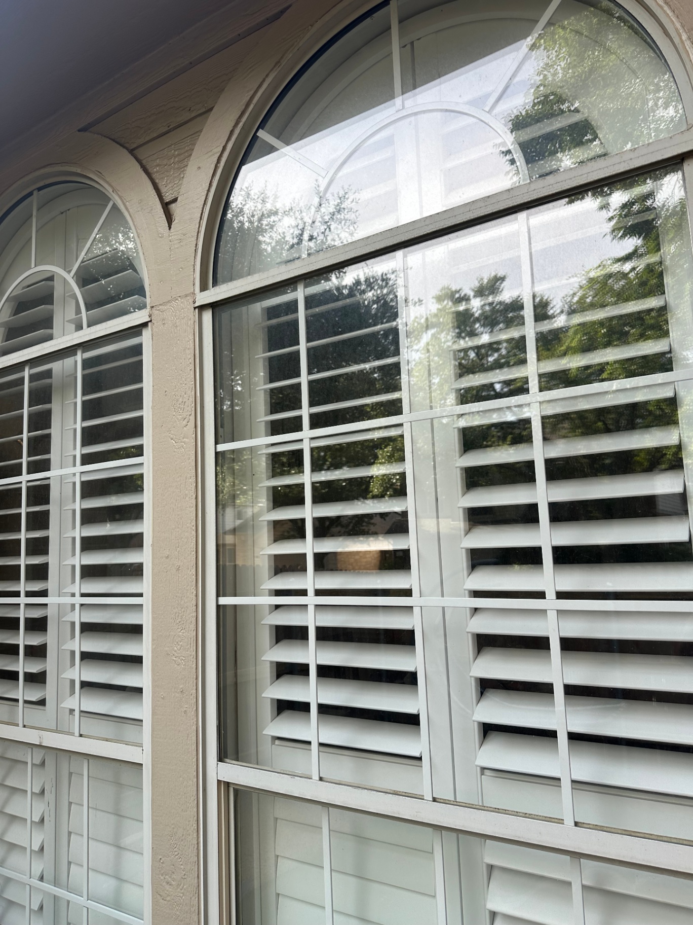 Arched windows with plantation shutters cleaned by Austin Clear